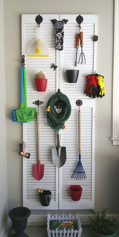 a white door with some gardening utensils hanging on it