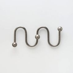 a pair of metal hooks on a white background with space for the letter u to be placed