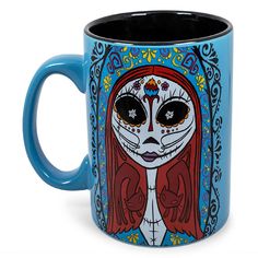 a blue coffee mug with an image of a woman's face painted on it