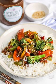 stir fry with broccoli, carrots and other vegetables in a white bowl