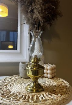 a vase with some flowers on top of a wicker table mat next to a mirror