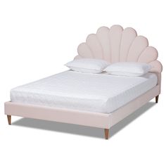 a bed with a pink shell headboard and foot board on it's side