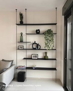 a living room filled with lots of shelves covered in vases and plants on top of them