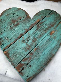 a heart shaped piece of wood sitting on top of snow