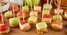 apples, caramel and apple slices are arranged on skewers