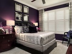 a bedroom with purple walls and white bedding