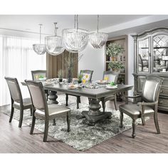 a dining room table and chairs with chandelier in the middle, along with an area rug on the floor