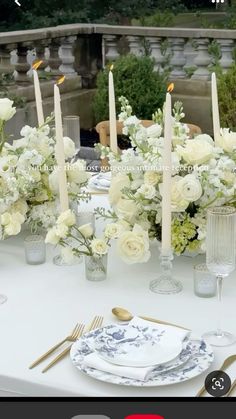 the table is set with white flowers and candles