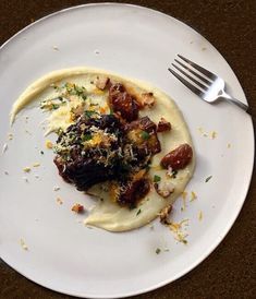 a white plate topped with food and a fork