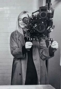 a woman holding up a camera in front of her face