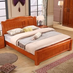 a large bed sitting on top of a hard wood floor next to a dresser and mirror