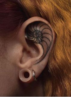 a woman's ear with an intricate design on the inside of her left ear