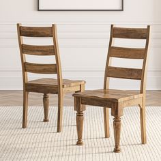 two wooden chairs sitting next to each other on top of a carpeted floor in front of a white wall