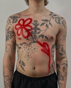 a man with tattoos on his chest has a red ribbon tied to the side of his body