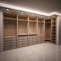 an empty walk - in closet with several drawers and hanging hooks on the wall,