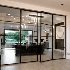 a living room filled with furniture and lots of glass doors that open up to the outside