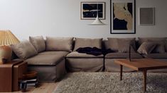 a living room filled with lots of furniture next to a wall mounted art piece on the wall