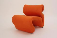 an orange chair sitting on top of a white floor next to a black leg rest