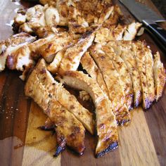 sliced up chicken on a cutting board with a knife