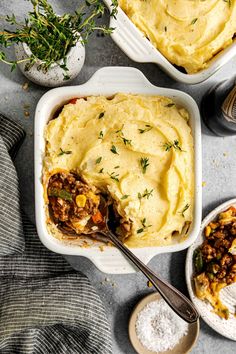 mashed potatoes with meat in a casserole dish on a gray surface next to other dishes