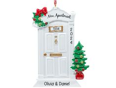 an ornament with a door and christmas tree on it's front porch