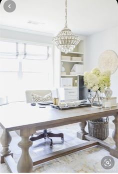 a large wooden table sitting in the middle of a living room next to a window