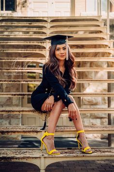 a woman sitting on top of a wooden bench wearing yellow shoes and a graduation cap