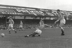 an old black and white photo of men playing soccer