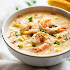 a white bowl filled with shrimp chowee next to a corn cob on the side