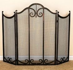 an iron fireplace screen is shown in the corner of a room with beige carpeting