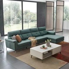 a living room filled with furniture next to large windows and a white coffee table on top of a rug