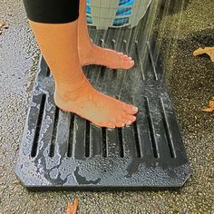 a person standing on top of a metal grate with their feet in the water