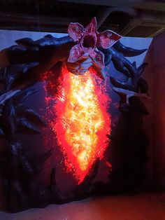 a sculpture with flames in the shape of a heart and flowers on it's face