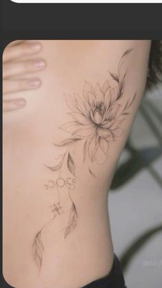 a woman's lower back tattoo with flowers on her left side and the bottom part of her stomach