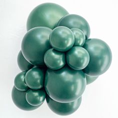 a bunch of green balloons floating on top of each other in the shape of a cluster