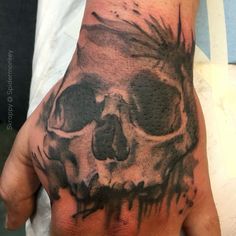 a man's hand with a skull tattooed on it