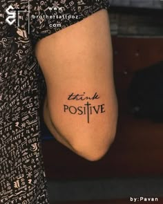 a person with a tattoo on their arm that says think positive