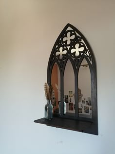 a mirror and some vases on a shelf