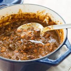 a pot filled with beans and meat on top of a table