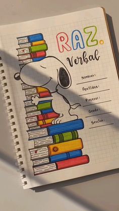 a notebook with a drawing of a snoopy reading a stack of books on top of it