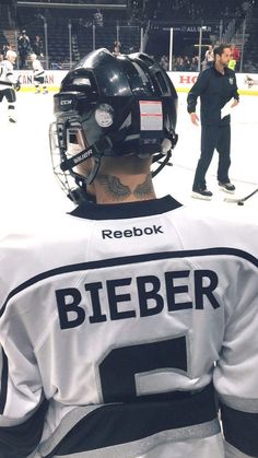 the back of a hockey player's jersey with tattoos on his arm and shoulder