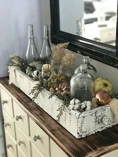 a wooden box filled with bottles sitting on top of a dresser next to a mirror