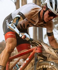 a man riding on the back of a bike down a dirt road