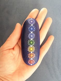 a hand holding a painted rock in it's palm