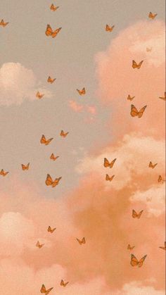 there are many small orange butterflies flying in the sky above some white clouds and pink clouds