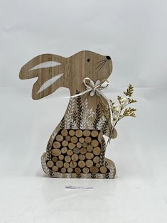 a wooden cutout of a rabbit holding a plant