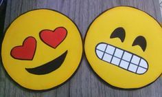 two smiley faces with hearts on them sitting next to each other in front of a table