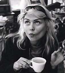 a black and white photo of a woman holding a coffee cup