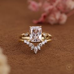 an engagement ring with a princess cut diamond surrounded by smaller round and pear shaped diamonds