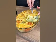 a person is spooning food out of a casserole dish on a table